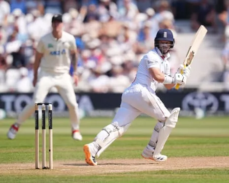 Ben Duckett in white plays a shot with a raised bat, fielders visible in the background
